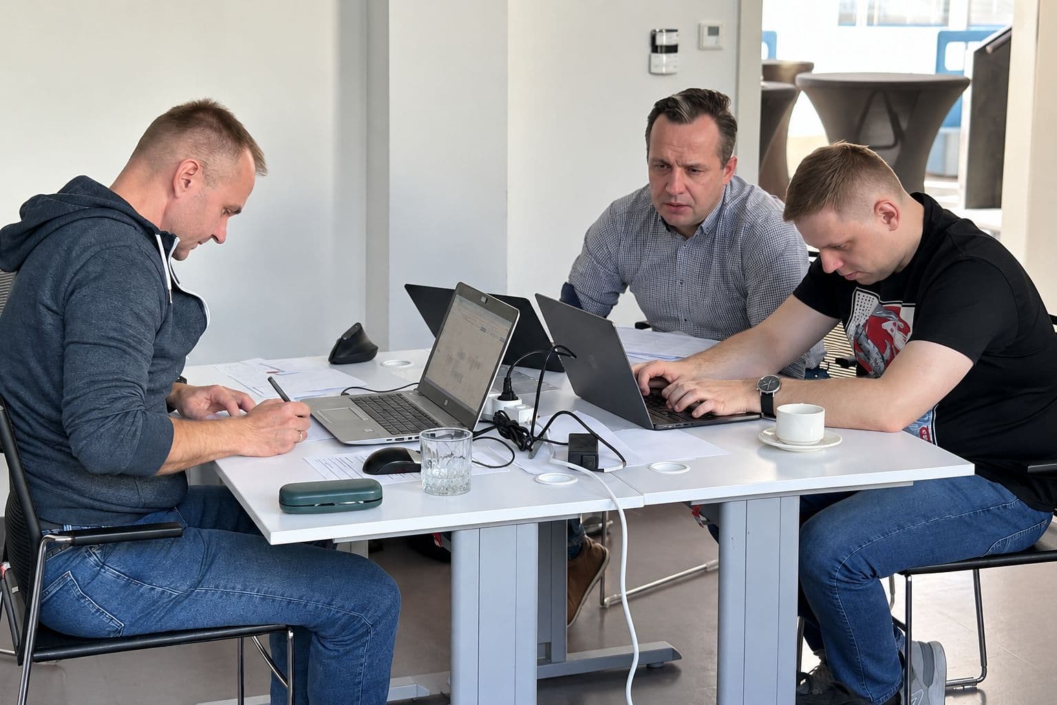 Uczestnicy przy laptopach analizują wspólnie rozwiązanie